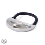 Silver hair tie with black elastic, featuring 18K gold geometric crescent design