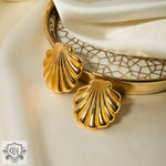 Two gold seashell earrings in 18K gold featuring a beach style light luxury design