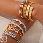 Assorted 18K gold and silver bracelets with sparkling diamonds and geometric design elements