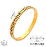 Gold-toned bangle featuring colorful gemstones and sparkling diamonds in 18K gold design