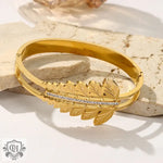 Gold-toned leaf-motif bangle showcasing unique artistic beauty in 18K gold with hollow designs