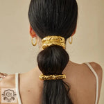 Woman’s black hair adorned with 18K gold light luxury style geometric hair accessories