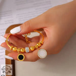 Gold-toned charm bracelet featuring high-quality 18K gold with round inlay design