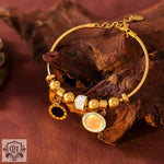 Gold-toned charm bracelet featuring high-quality 18K gold and round inlay design