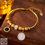 Gold-toned charm bracelet featuring decorative beads and pendants in high-quality 18k gold