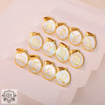 Gold-trimmed zodiac sign pendants on an 18K gold round pendant collection