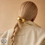 Blonde braid adorned with 18K gold geometric design hair accessories