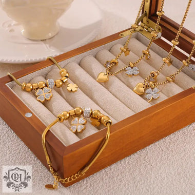 Gold-toned 18K Gold jewelry set featuring lucky four-leaf clover and heart charms