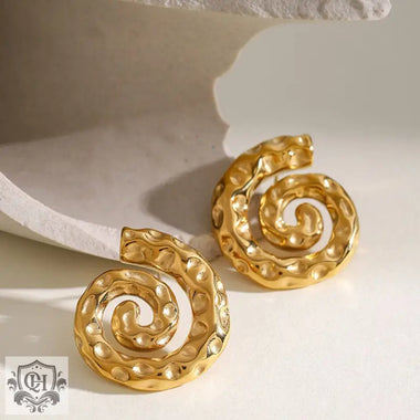 Hammered gold spiral earrings featuring a unique snail shape in 18K gold with a hammer pattern