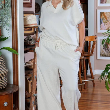 Woman in a white lounge set showcasing Beige Plus Size Textured Collared Top and Pants Set