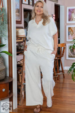 Woman in a white lounge set showcasing Beige Plus Size Textured Collared Top and Pants Set