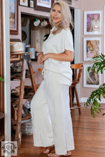 Woman in cream-colored lounge set from Beige Plus Size Textured Collared Top and Pants Set