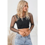 Sheer black mesh crop top with pearl embellishments paired with light wash denim jeans