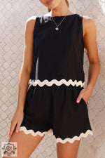 Black sleeveless romper featuring white ric-rac trim, perfect for relax relax occasions