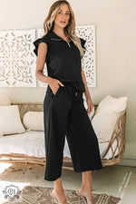 Woman in black two-piece outfit showcasing Black Textured Flutter Sleeve Top Wide Leg Pants Set