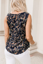 Sleeveless navy floral blouse with pink flower pattern paired with white pants in Relax Relax