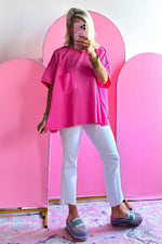 Hot pink oversized t-shirt with pockets styled with light blue cropped pants and gray loafers