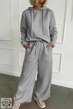 Gray quilted lounge set featuring wide leg pants and drawstring hoodie for ultimate relaxation