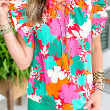 Vibrant floral blouse in pink, turquoise, and orange with green shorts for relax relax styles