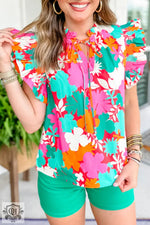 Vibrant floral blouse in pink, turquoise, and orange with green shorts for relax relax styles