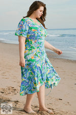 Floral print wrap dress featuring green leaves, plus size with ruffled hem for relaxed style