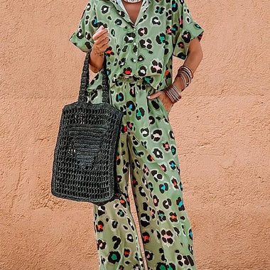 Woman wearing a stylish green leopard print short sleeve shirt and wide leg pants set