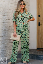 Woman wearing a green leopard print short sleeve shirt and wide leg pants set