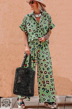 Woman wearing a green leopard print short sleeve shirt and wide leg pants set