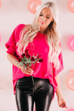 Hot pink oversized sweater with ruffled sleeves and black leather pants, relax relax styles