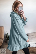 Light blue ruffled hoodie featuring a relaxed fit and stylish ruffled hem design