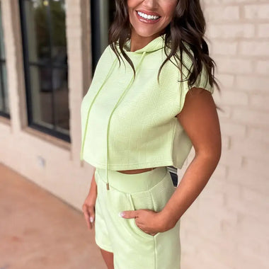 Woman wearing Meadow Mist Green Textured Cropped Hoodie and Shorts Set for relaxed style