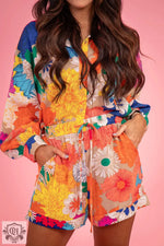 Colorful floral romper with long sleeves in vibrant yellow, orange, and blue pattern