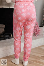 Pink pajama pants with snowflake print for cozy Christmas loungewear and relaxation