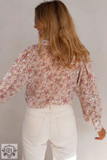 Pink Floral Print Bishop Sleeve Collared V Neck Shirt tucked into white pants, relax style