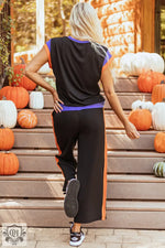 Woman wearing a black and orange track suit from Strawberry Pink Color Block two-piece set