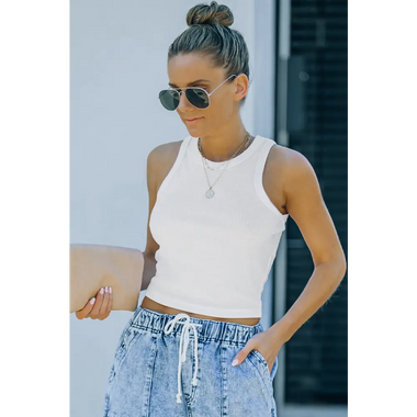 White sleeveless crop top with high-waisted denim jeans showcasing bust shoulder length fit