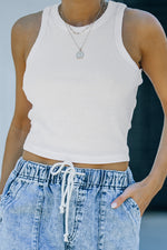 White ribbed tank top showcasing sizes bust shoulder, paired with acid-wash denim joggers