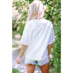 White MAMA Chenille Patched Crew Neck T Shirt styled with denim cutoff shorts for relaxed look