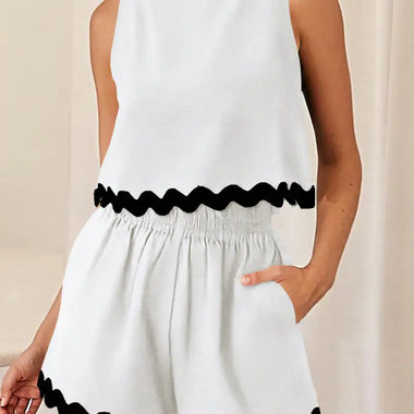 White sleeveless romper with black scalloped trim for stylish summer relax relax