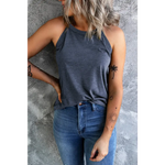 Woman wearing a white solid color crew neck tank top paired with jeans