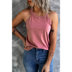 Woman in pink tank top and blue jeans showcasing a white solid color crew neck tank top