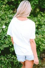 Person in White Star Patchwork Loose T-shirt with light denim shorts for relaxed style