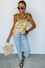 Person in yellow floral tank top and distressed jeans showcasing relaxed summer style