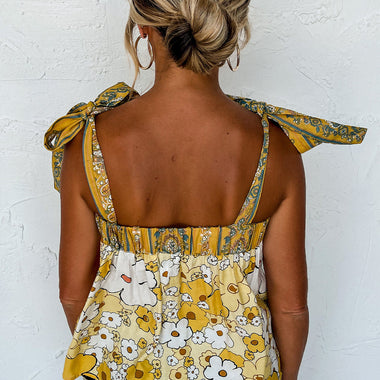 Floral yellow and white sleeveless top with tied straps and gathered waist in various sizes