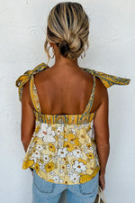 Floral yellow and white sleeveless top with tied straps and gathered waist in various sizes